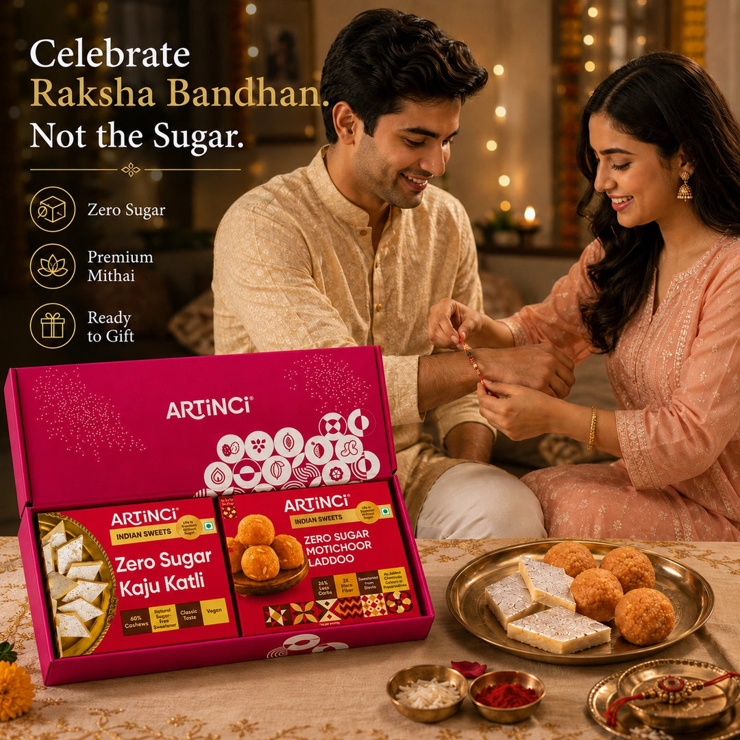 A couple seated together in a warmly lit indoor setting, receiving sweet snacks while an open pink ARTINCI gift box with two packaged zero-sugar items is shown in the foreground. Text on the left reads 'Celebrate Raksha Bandhan.